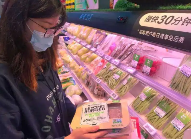 一位消费者正在深圳盒马IBC店挑选人造肉产品